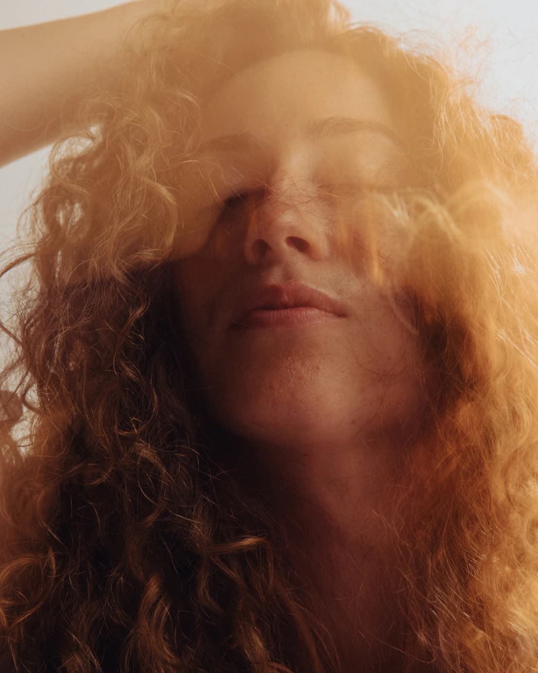 Woman with glowing skin and eyes closed, receiving a facial or gentle massage